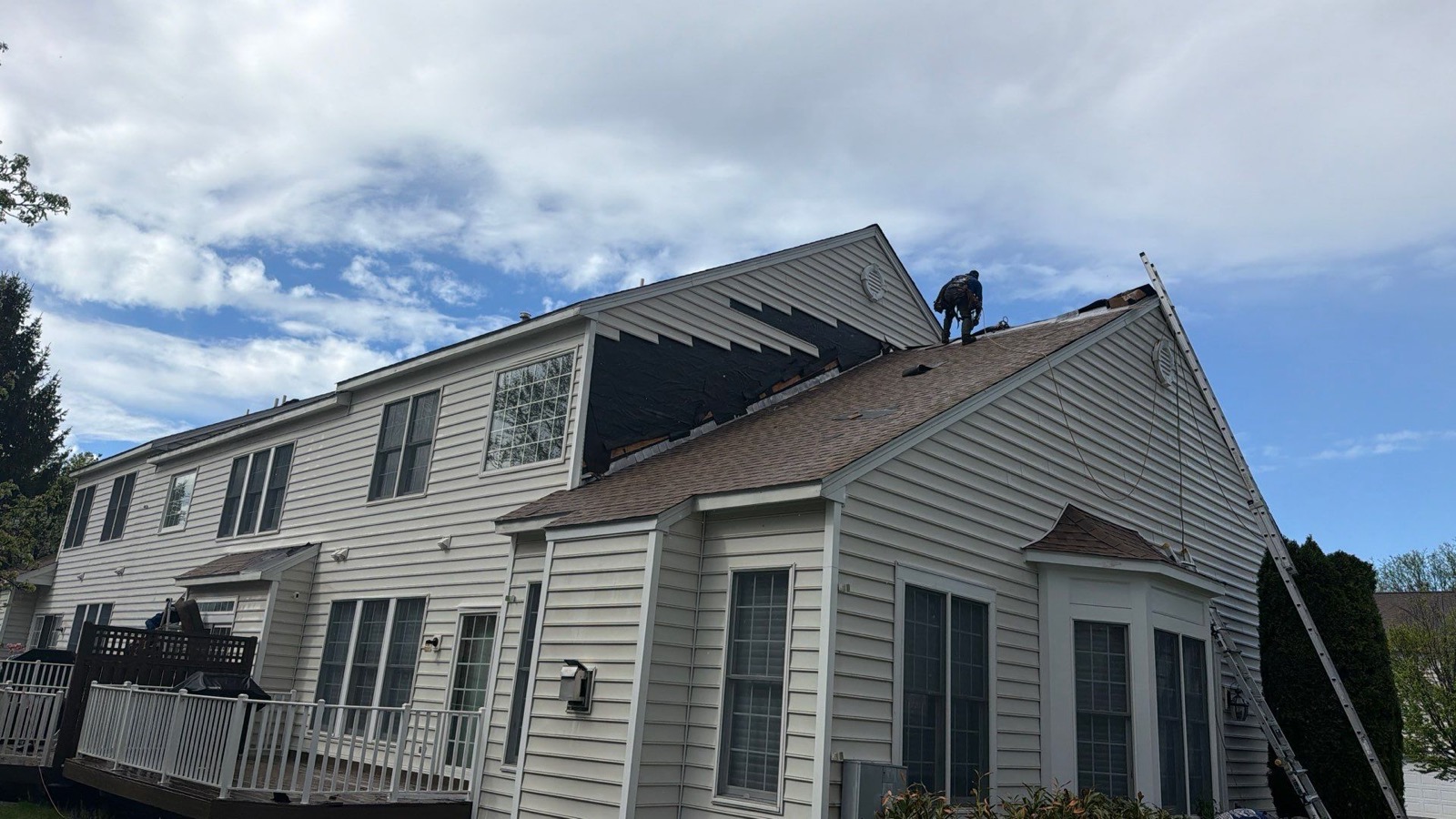 Finished suburban colonial with new GAF shingle roof viewed from the street on a clear day