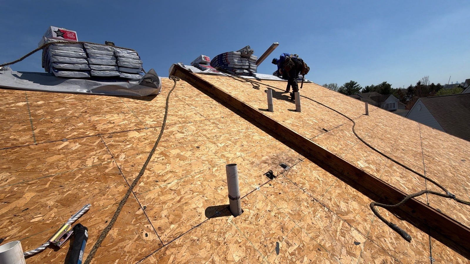 Drone view of the full LGM crew working a large suburban roof replacement with FeltBuster and materials everywhere