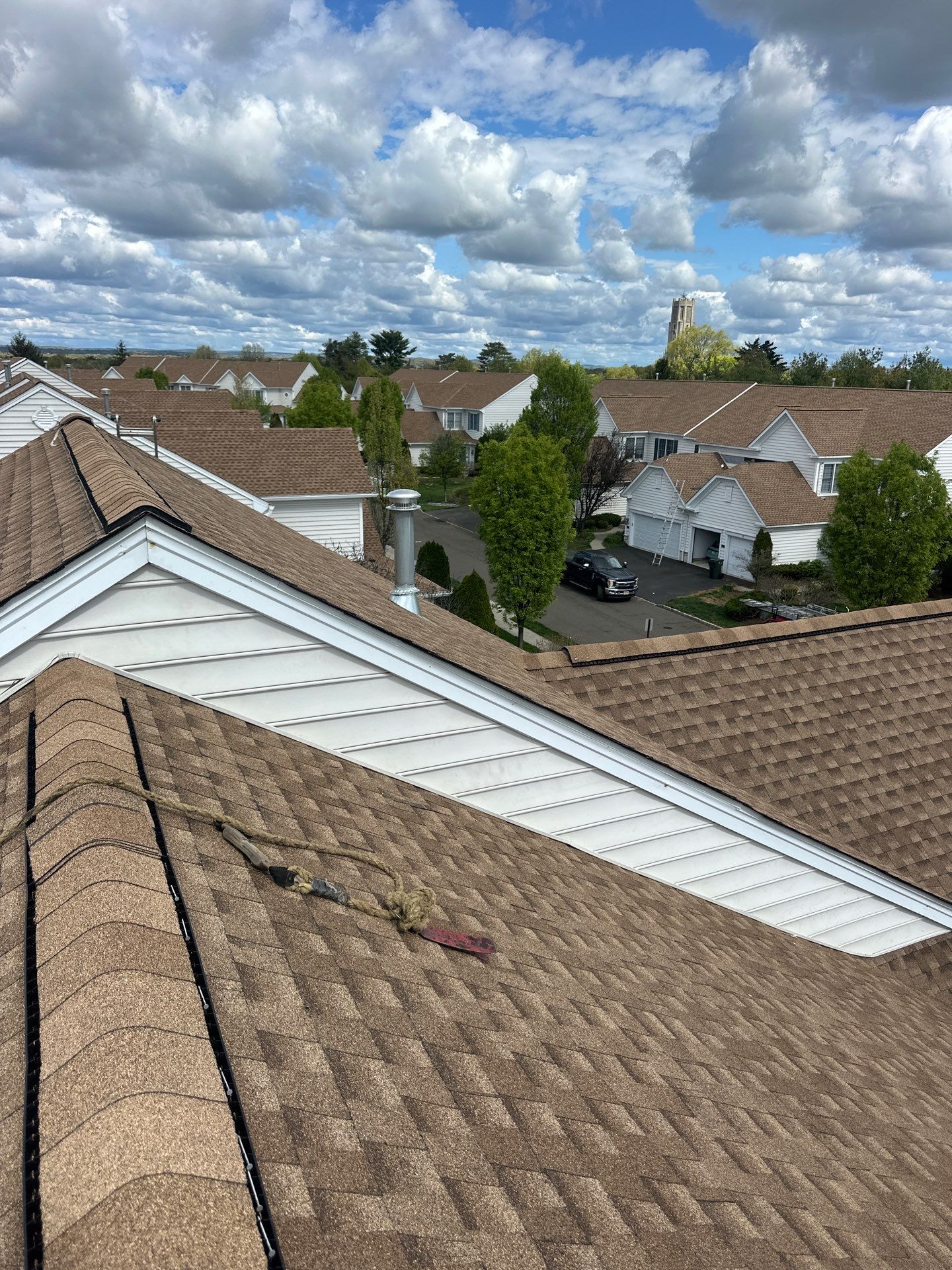 LGM roofer nailing GAF Timberline HDZ shingles over FeltBuster underlayment on a suburban colonial
