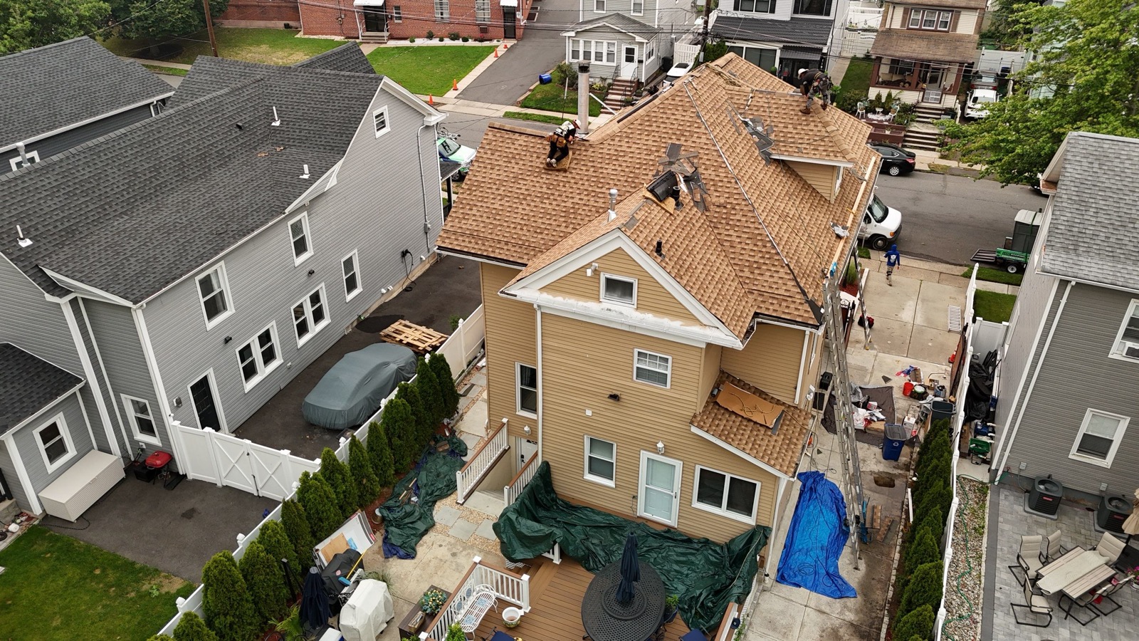 Drone angle of a completed tan shingle roof on a Victorian with dormers and bay windows