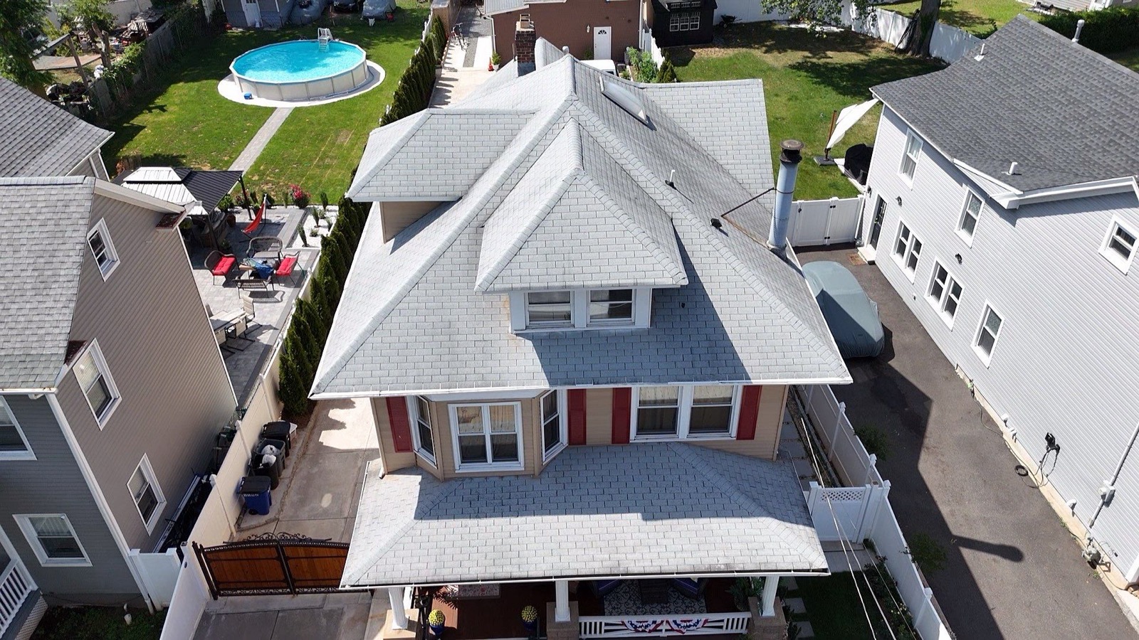Drone overhead of a completed roof on a Victorian home with red shutters and tan GAF shingles in North Jersey