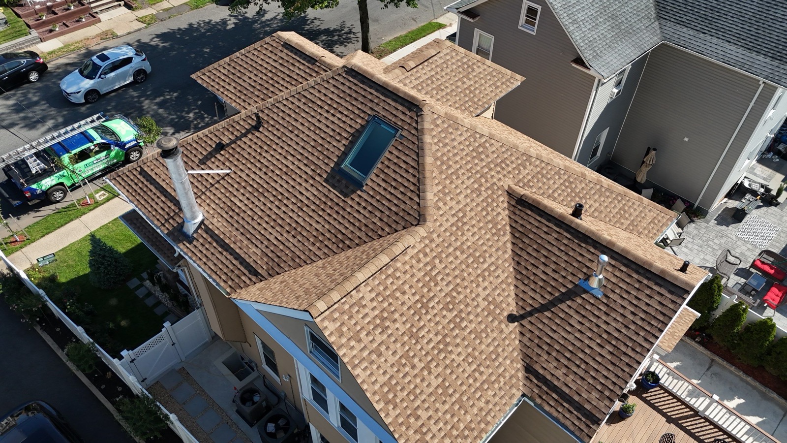 Completed Victorian home with new tan shingle roof viewed from the front showing all dormers and the front porch