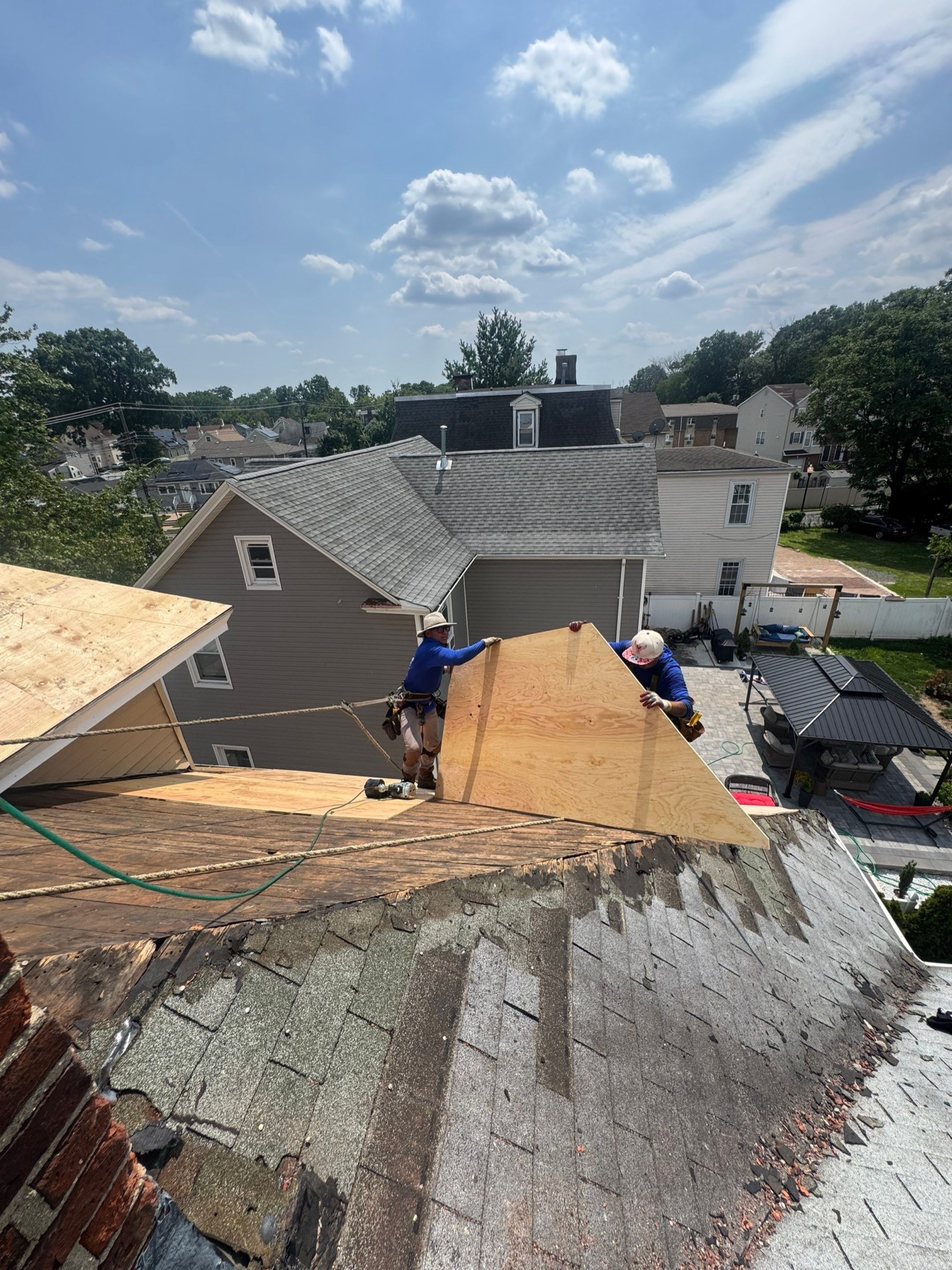LGM crew stripping old roofing on a Victorian while heavy tarps protect the siding and landscaping below
