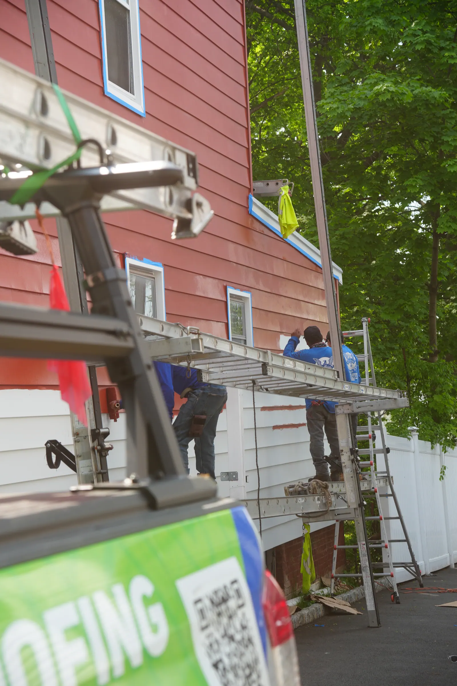 LGM crew member aligning a course of siding against a window opening