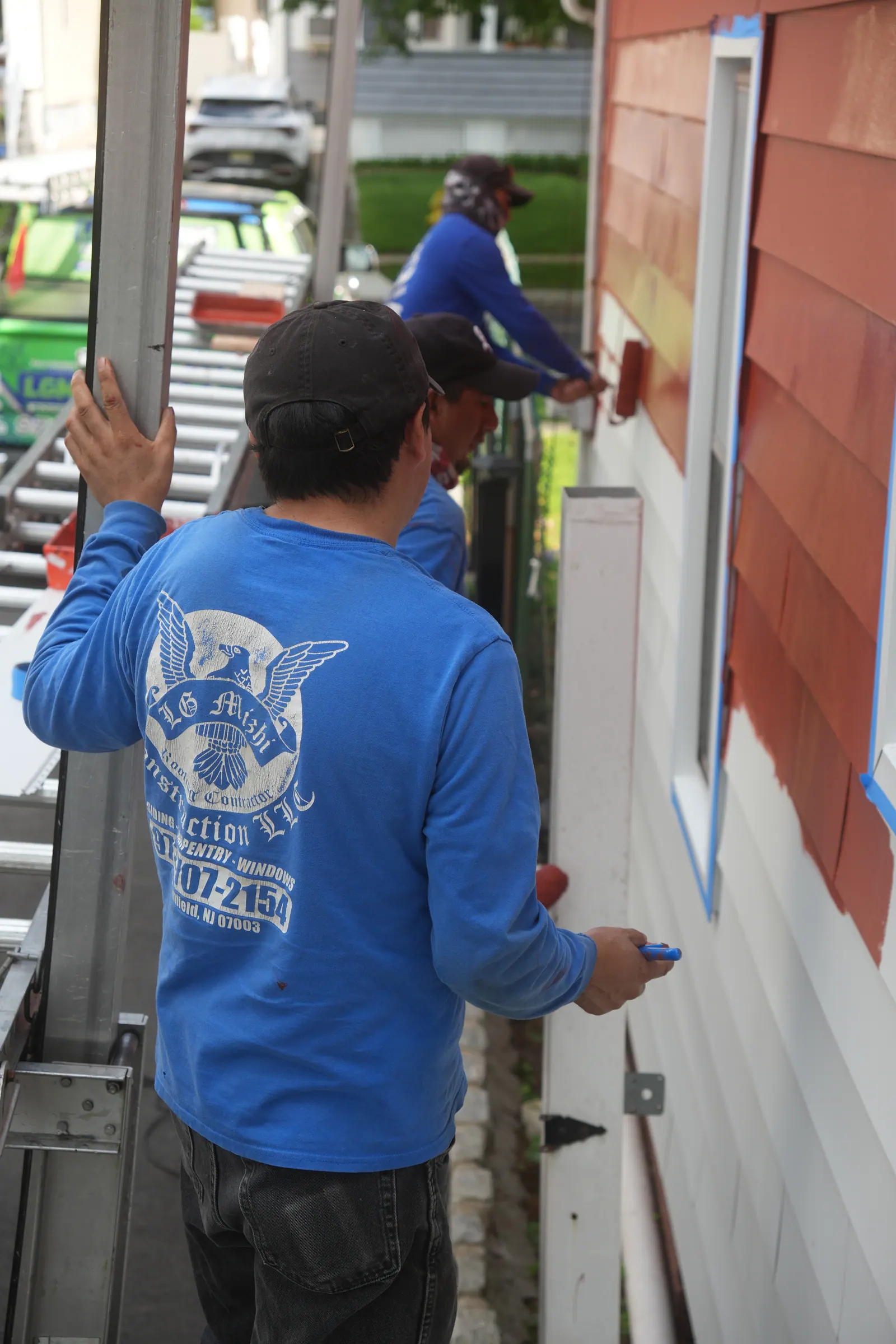 LGM crew member fitting a siding panel on a North Jersey home