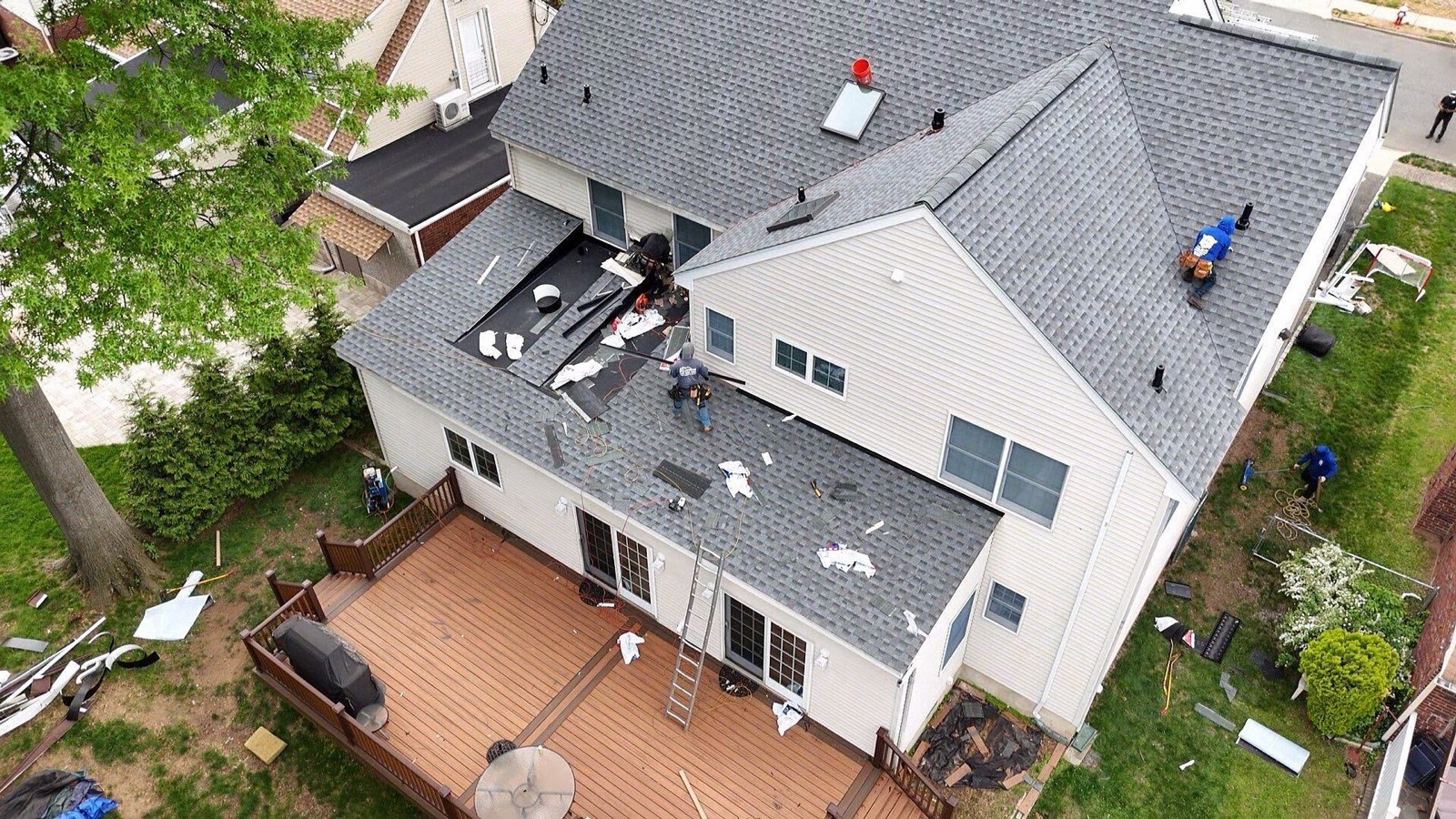 Drone shot of LGM crew actively working a roof replacement with debris chute and materials staged
