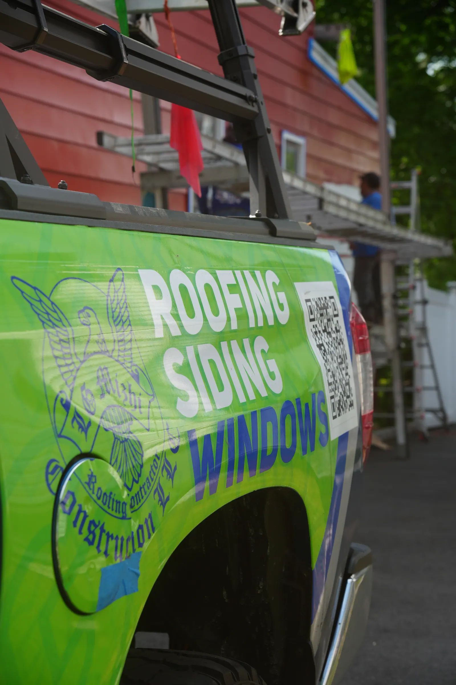 Close-up of the LGM Roofing truck wrap reading Roofing, Siding, Windows