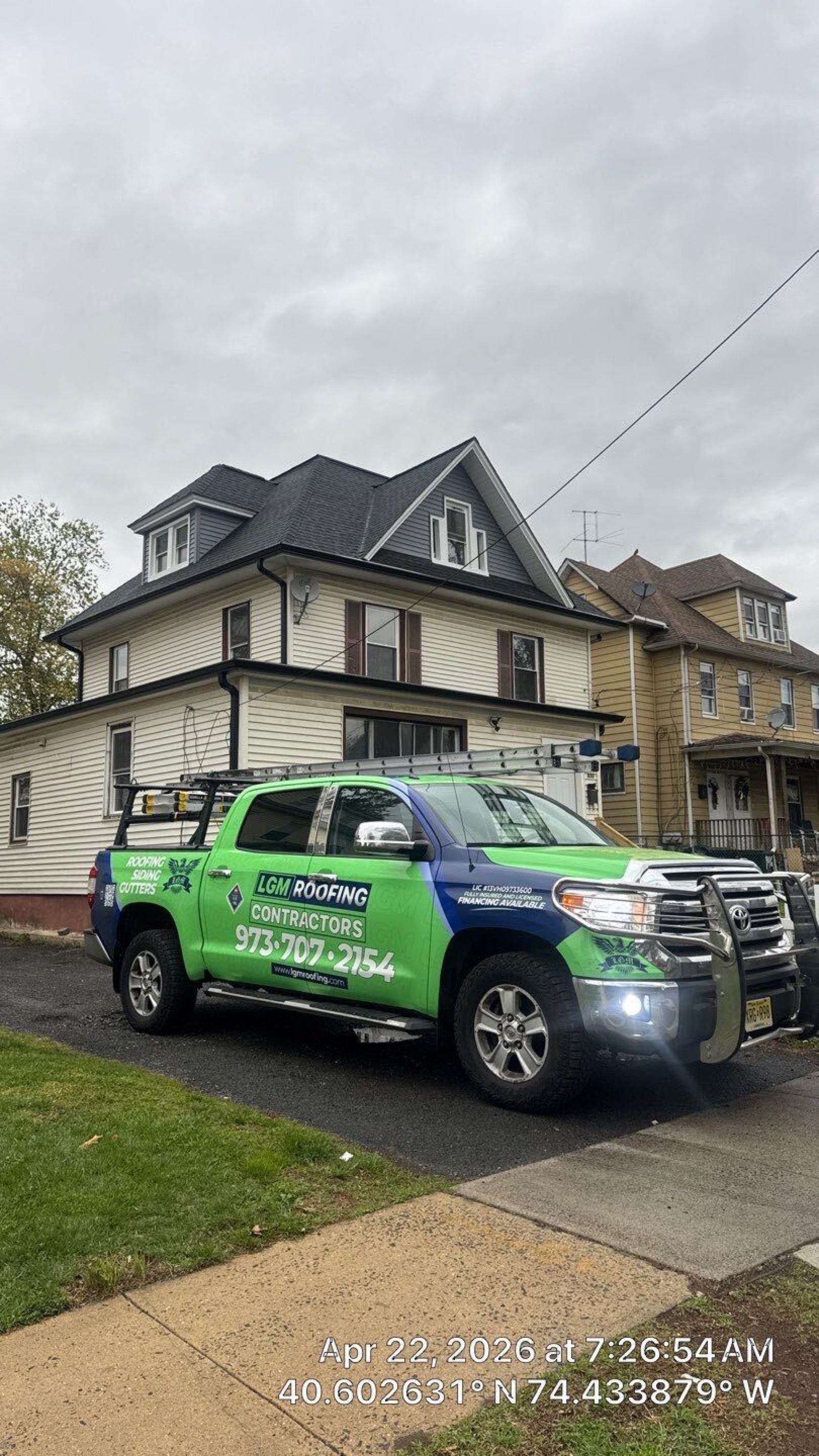 LGM Roofing Contractors branded truck with full green-and-blue wrap showing phone number and license