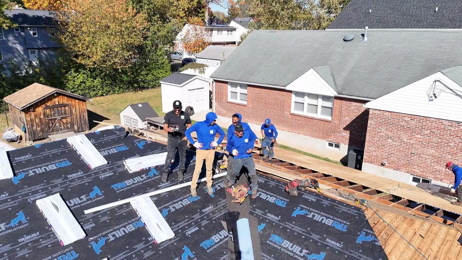 LGM crew rolling underlayment across a newly decked roof