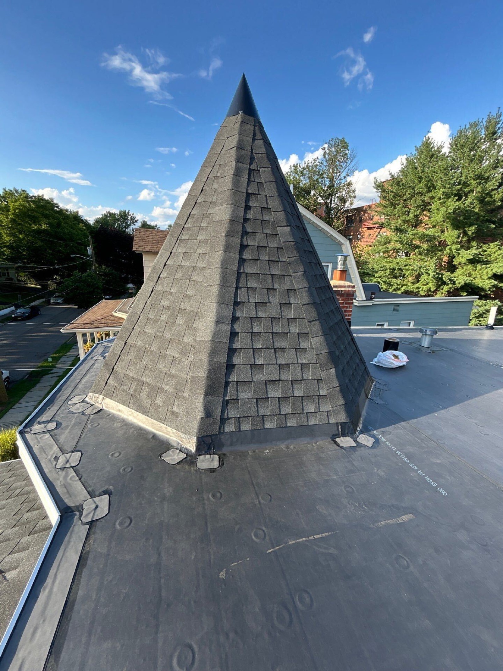 Shingled turret roof meeting an EPDM flat section on a Victorian-style North Jersey home