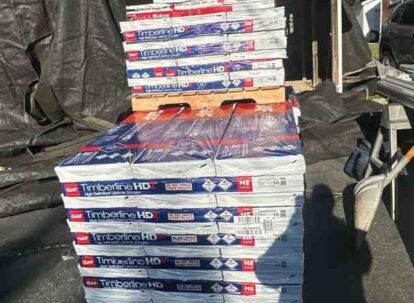 roofing contractor inspecting shingles on a home roof
